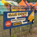 Crowd Barrier Banners: Printed car boot sale banner on a fence at an event