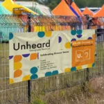 Crowd Barrier Banners: Printed festival banner on a fence at an outdoor event